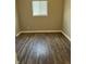 Bedroom featuring wood-look flooring, neutral walls, and a bright window at 3642 Horth Ct, Indianapolis, IN 46235