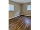 Bright bedroom showcasing wood-look floors, gray walls, and two windows for ample light at 3642 Horth Ct, Indianapolis, IN 46235