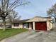 Ranch-style home featuring a red garage door, lush green lawn, and a paved driveway at 3841 Monica Ct, Indianapolis, IN 46226