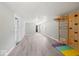 Finished basement with light gray walls and flooring, featuring a wall mounted climbing gym and brightly colored mats at 415 Elm Ave, Sheridan, IN 46069