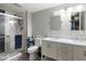 Updated bathroom featuring a double vanity, a tiled shower with glass doors, and modern fixtures at 415 Elm Ave, Sheridan, IN 46069