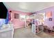 Bright bedroom featuring pink and purple walls, a bunk bed with a desk, creating a fun and functional space at 415 Elm Ave, Sheridan, IN 46069