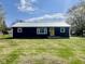 Charming home featuring a metal roof, yellow door, and lush green lawn at 415 Elm Ave, Sheridan, IN 46069