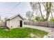 View of the backyard, detached garage, gravel driveway, and wooden fence at 420 Orange St, Indianapolis, IN 46225