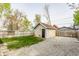 View of the backyard, detached garage, gravel driveway, and wooden fence at 420 Orange St, Indianapolis, IN 46225
