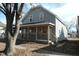 Two-story gray home with decorative wooden shutters and a cozy front porch with black metal railings at 425 N Grant Ave, Indianapolis, IN 46201