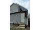 Back of the house with siding and a door with damaged trim at 425 N Grant Ave, Indianapolis, IN 46201