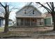 Exterior shot highlighting the home's porch and gray siding against a leafy backdrop at 425 N Grant Ave, Indianapolis, IN 46201