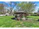 Serene backyard featuring a charming gazebo, lush lawn, and mature trees, creating a peaceful outdoor retreat at 4337 Lincoln Rd, Indianapolis, IN 46228