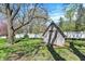 A backyard shed sits in a grassy yard behind a white fence at 4337 Lincoln Rd, Indianapolis, IN 46228