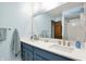 Bright bathroom featuring double sinks set within a quartz countertop and blue cabinets with a shower/tub combo at 4337 Lincoln Rd, Indianapolis, IN 46228