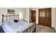 Cozy bedroom featuring a metal bed frame and natural wood closet doors and trim, plus neutral colored carpet at 4337 Lincoln Rd, Indianapolis, IN 46228