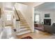 Inviting hallway with hardwood floors and staircase, leading to a view of the living room at 4343 N Pennsylvania St, Indianapolis, IN 46205