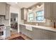 Well-lit kitchen features gray cabinets, farmhouse sink, stainless steel appliances and brick flooring at 4343 N Pennsylvania St, Indianapolis, IN 46205