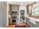 Kitchen with stainless steel appliances, gray cabinets, brick floors and view into other rooms at 4343 N Pennsylvania St, Indianapolis, IN 46205