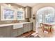 Kitchen with stainless steel appliances, gray cabinets, brick floors and adjacent eating area at 4343 N Pennsylvania St, Indianapolis, IN 46205