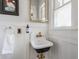 Powder room features a unique sink, mirror, gold fixtures and stylish decor at 4343 N Pennsylvania St, Indianapolis, IN 46205