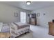 Bright bedroom with plush carpeting, window, bed, and wooden dresser with television at 4412 Mountbatten Ct, Indianapolis, IN 46254