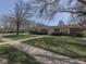 Beautiful brick home with a well-maintained lawn, shrubs, and mature trees at 4412 Mountbatten Ct, Indianapolis, IN 46254