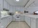 View of kitchen with white cabinetry, modern appliances, and tiled countertops at 4412 Mountbatten Ct, Indianapolis, IN 46254