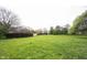 A large, grassy backyard with mature trees and a wooden fence at 4545 Connaught East Dr, Plainfield, IN 46168