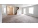 Spacious living room showcasing neutral walls, soft carpeting, and access to the backyard and upper level at 4545 Connaught East Dr, Plainfield, IN 46168