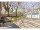 Spacious backyard featuring a detached two-car garage, mature trees, and a lawn at 4640 Boulevard Pl, Indianapolis, IN 46208