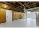 Spacious basement with exposed wood beams, wooden cabinetry, and white painted floors at 4640 Boulevard Pl, Indianapolis, IN 46208