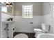 Bright bathroom featuring white wainscoting, a pedestal sink, and modern fixtures at 4640 Boulevard Pl, Indianapolis, IN 46208