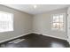 Empty bedroom with hardwood floors, two windows, and neutral paint at 4640 Boulevard Pl, Indianapolis, IN 46208