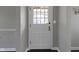 Bright entryway featuring a white door with glass panels and dark hardwood floors at 4640 Boulevard Pl, Indianapolis, IN 46208