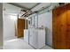 Basement laundry room with washer, dryer, and a vintage wooden door at 4640 Boulevard Pl, Indianapolis, IN 46208