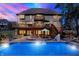 Gorgeous backyard featuring a sparkling pool, patio, and lush landscaping at dusk at 4843 Snowberry Bay Ct, Carmel, IN 46033