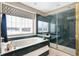 Beautiful bathroom with tub and shower featuring luxury marble finishes and a picture window with views at 4843 Snowberry Bay Ct, Carmel, IN 46033