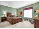 Serene bedroom with green walls, carpet, and a comfortable bed complemented by bedside lamps and dresser at 4843 Snowberry Bay Ct, Carmel, IN 46033