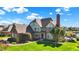 A manicured front yard and brick exterior of a spacious Tudor style home on a sunny day at 4843 Snowberry Bay Ct, Carmel, IN 46033