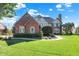 Charming brick and tudor home with manicured front lawn and mature trees under a blue sky at 4843 Snowberry Bay Ct, Carmel, IN 46033