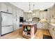 Bright kitchen featuring stone countertops, stainless appliances, central island with bar stool seating, and wooden floors at 4843 Snowberry Bay Ct, Carmel, IN 46033