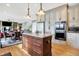 A modern kitchen features an island with granite countertops, wooden floors, and stainless steel appliances at 4843 Snowberry Bay Ct, Carmel, IN 46033