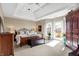 Large bedroom features coffered ceiling, balcony access, plush carpet, and ample natural light at 4843 Snowberry Bay Ct, Carmel, IN 46033
