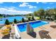 Relaxing in-ground pool with clear blue water and scenic lake views surrounded by lush landscaping and inviting lounge seating at 4843 Snowberry Bay Ct, Carmel, IN 46033