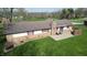 Aerial view of a backyard featuring a stone patio with outdoor seating and well-maintained lawn at 5210 S 100 E Rd, Anderson, IN 46013