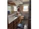 Well-lit bathroom with a wooden-framed mirror, vanity, and updated fixtures at 5210 S 100 E Rd, Anderson, IN 46013