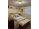 Cozy bedroom featuring floral wallpaper, a brass bed frame, and a matching quilt at 5210 S 100 E Rd, Anderson, IN 46013