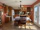 Sunlit dining room featuring a floral tablecloth, hanging chandelier, and natural wood cabinetry at 5210 S 100 E Rd, Anderson, IN 46013