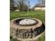 A stone fire pit is the focal point of the backyard, set in a lush green lawn at 5210 S 100 E Rd, Anderson, IN 46013