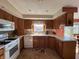 Functional kitchen with a window above the sink, white appliances, and oak-colored cabinetry at 5210 S 100 E Rd, Anderson, IN 46013