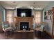 Cozy living room featuring a fireplace, comfortable seating, and natural light from large windows at 5210 S 100 E Rd, Anderson, IN 46013