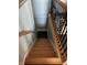 A stairway showcasing wooden steps and a black wrought iron railing leading to lower level at 5210 S 100 E Rd, Anderson, IN 46013