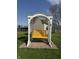 A charming yellow yard swing sits beneath a white arbor in the sprawling backyard at 5210 S 100 E Rd, Anderson, IN 46013